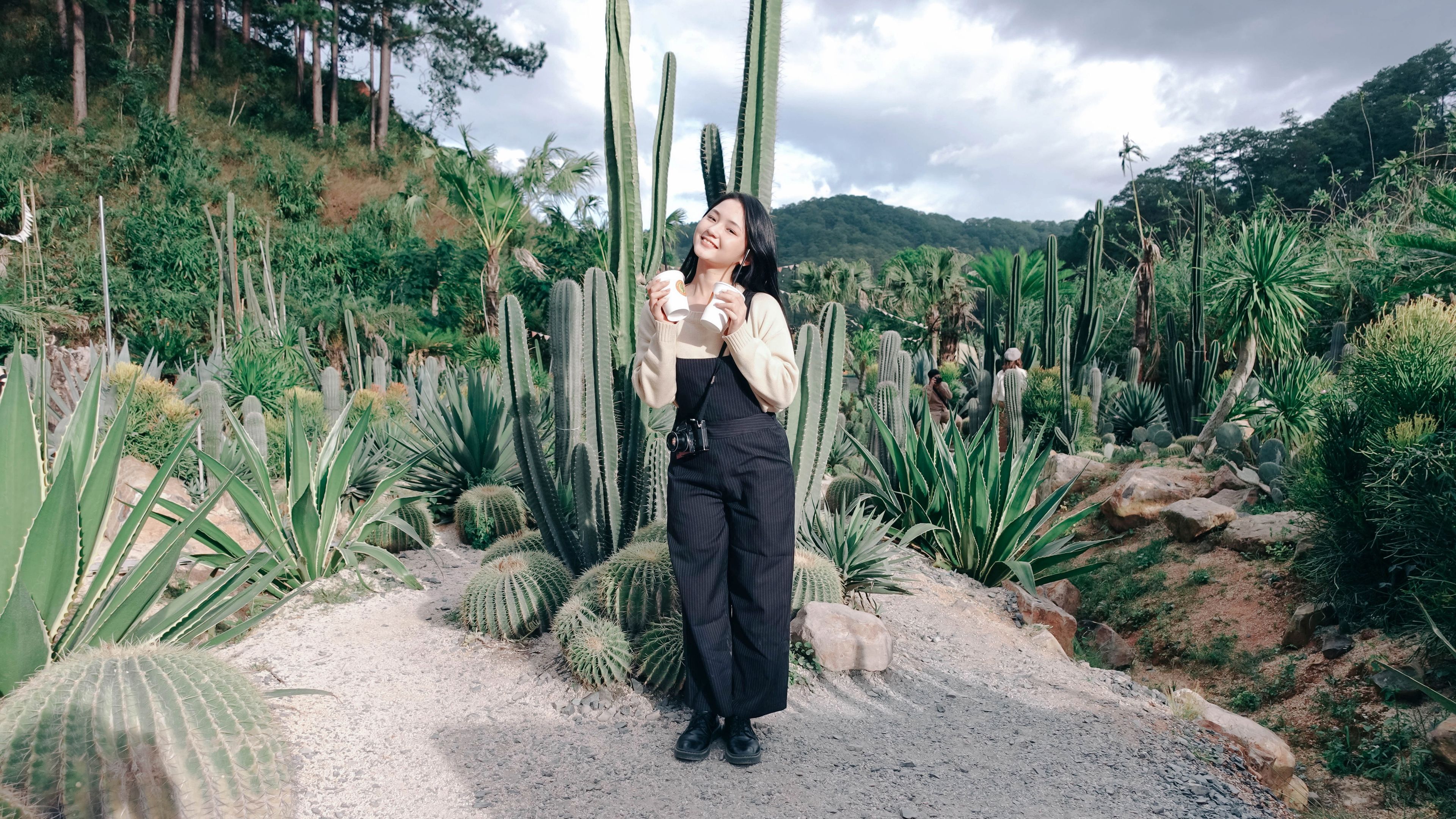 A girl in wide-leg pants standing near to cactus