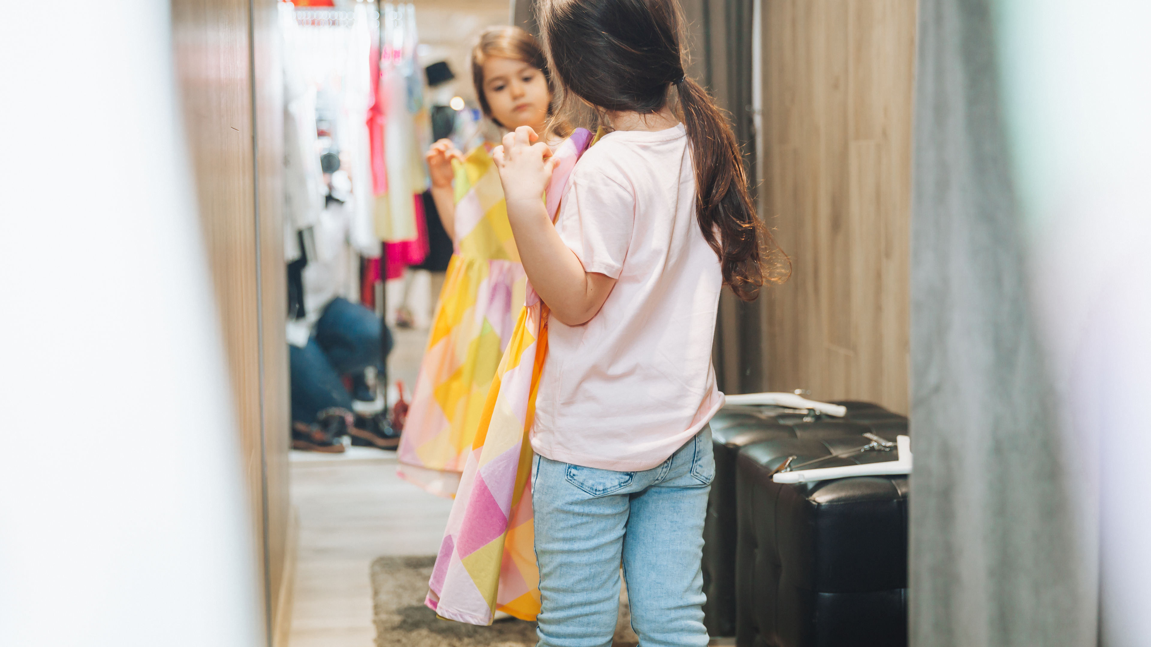 The mother and daughter share a fun shopping experience as they pick out and try vibrant dresses 