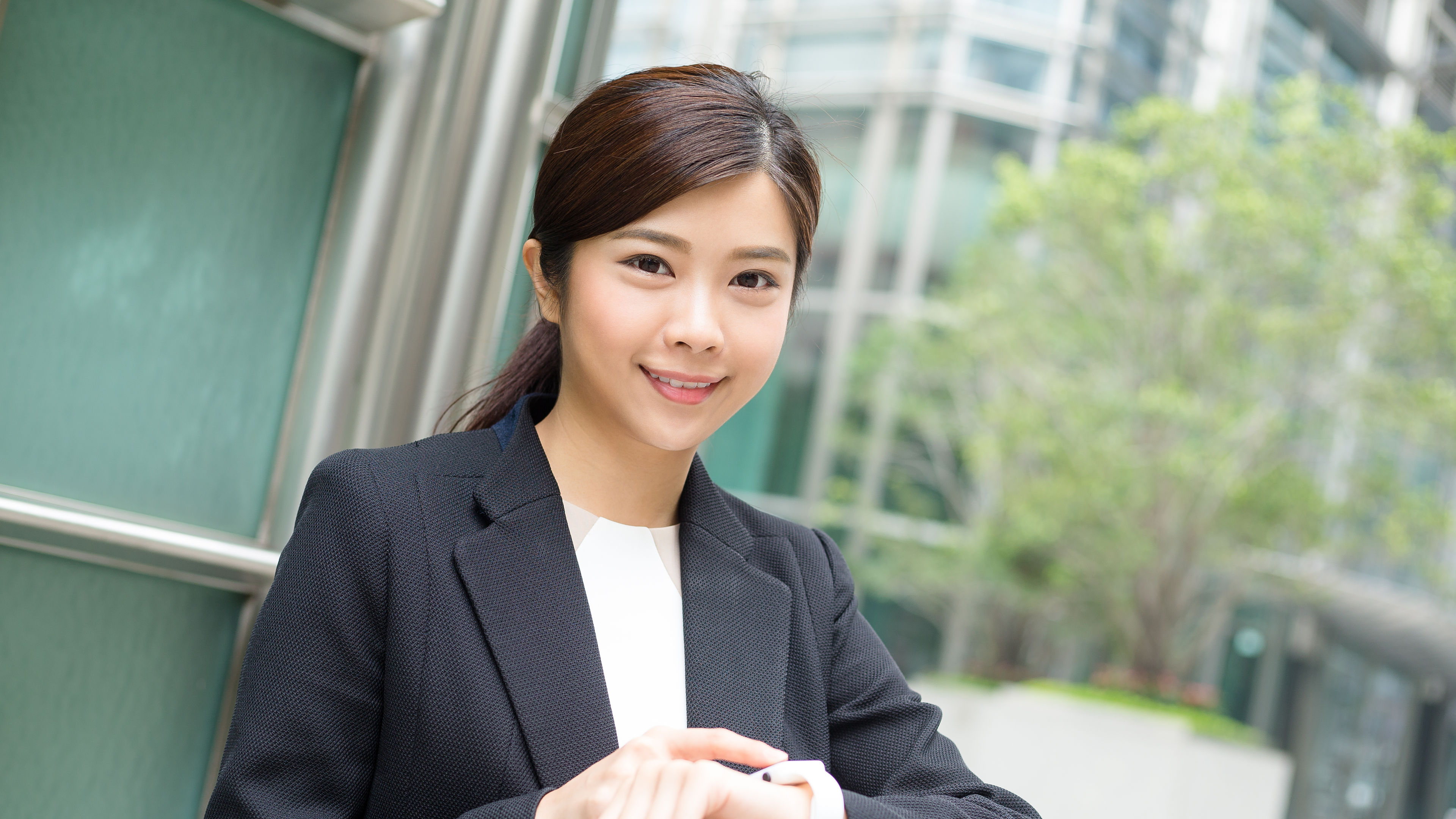 A confident businesswoman checks her smartwatch 