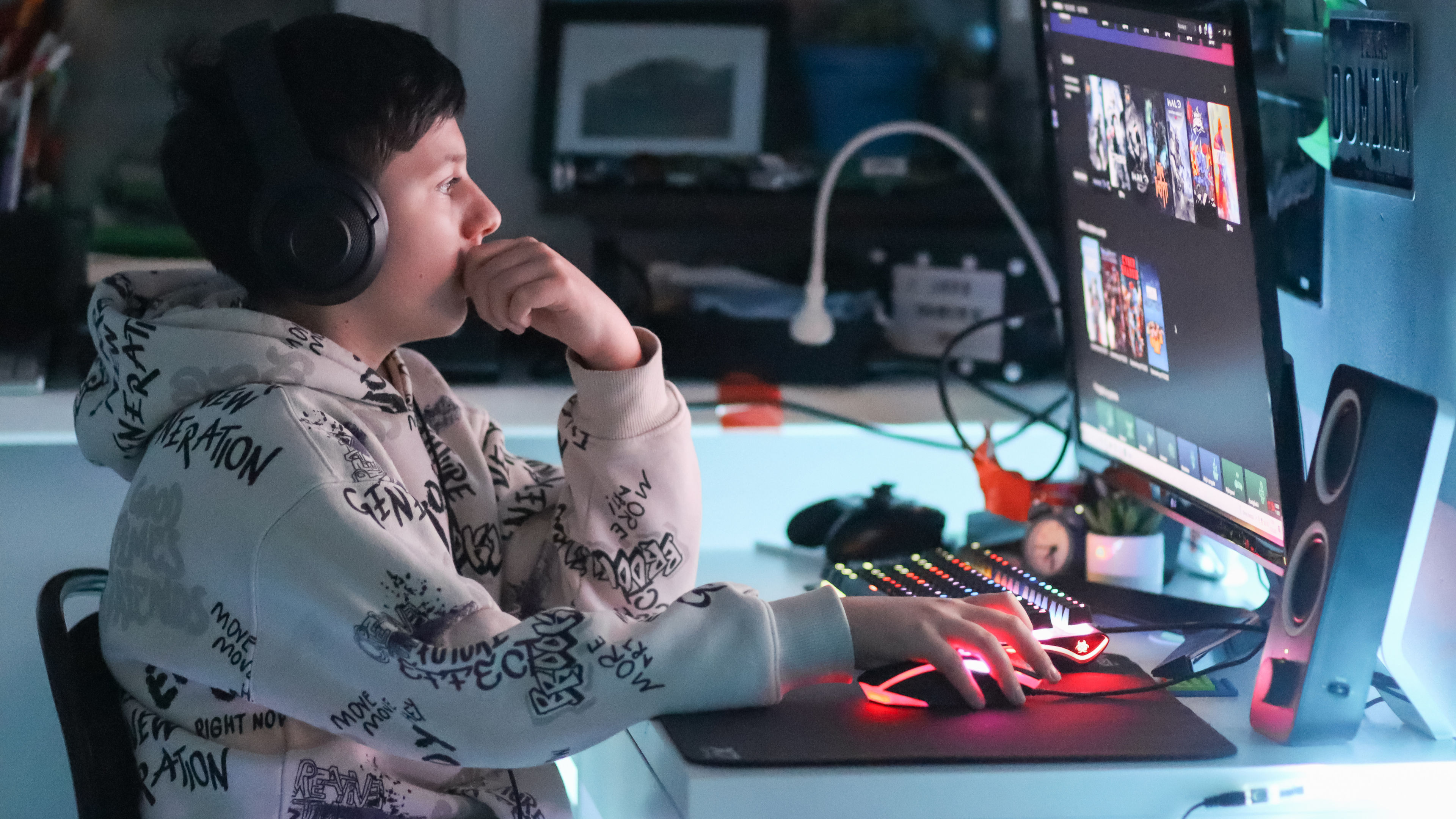 A teenager, deeply immersed in the virtual world, is playing a computer game. 