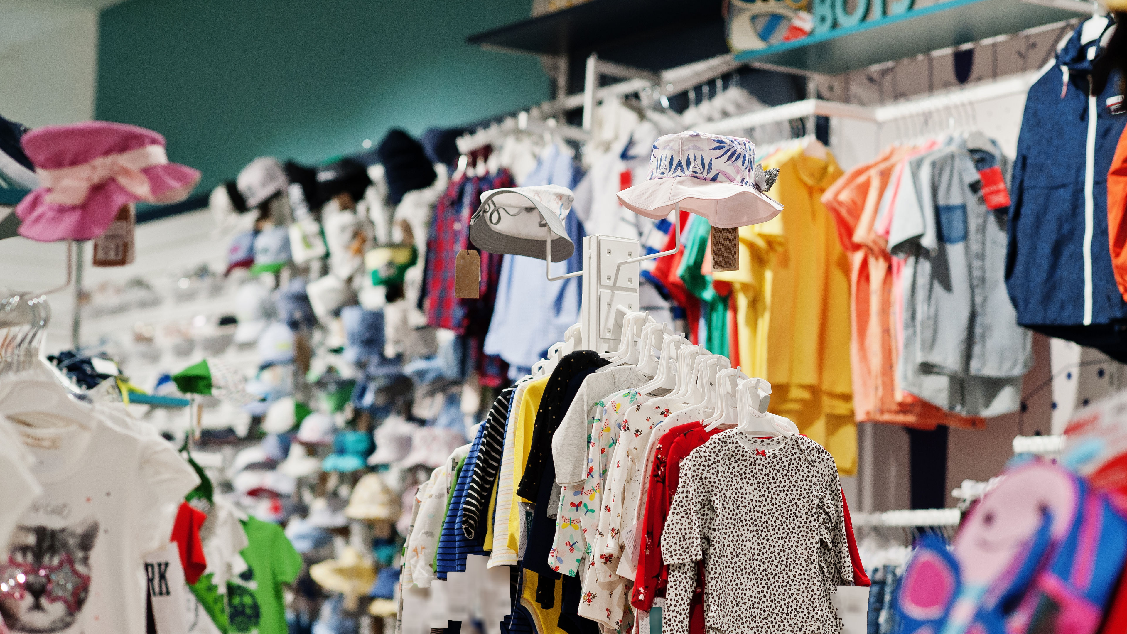 The boutique showcases a lively array of children’s apparel, with bright colors and playful patterns 
