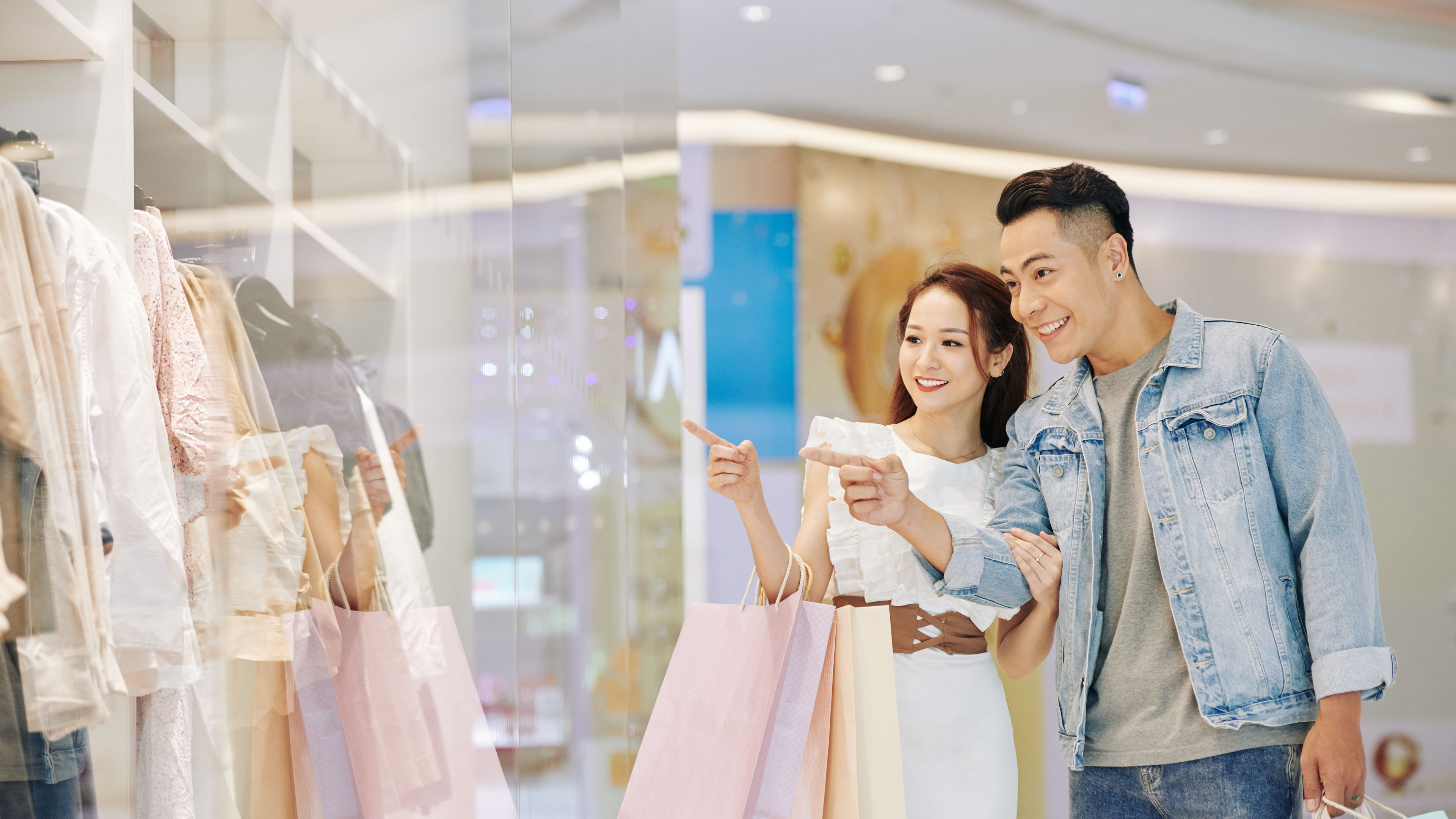 A happy woman and a man shopping in a mall 