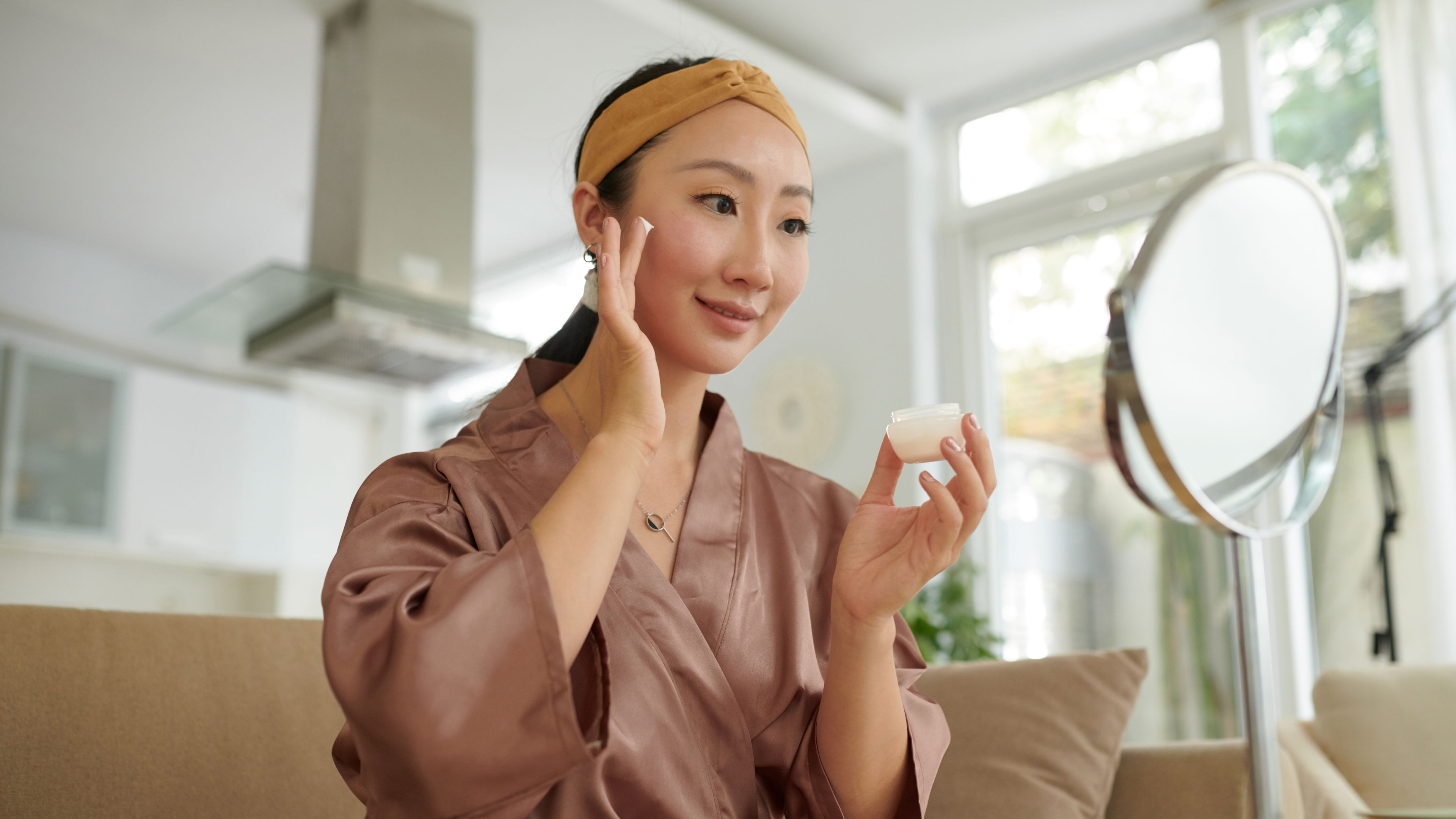 A woman applying anti-ageing cream on her face 