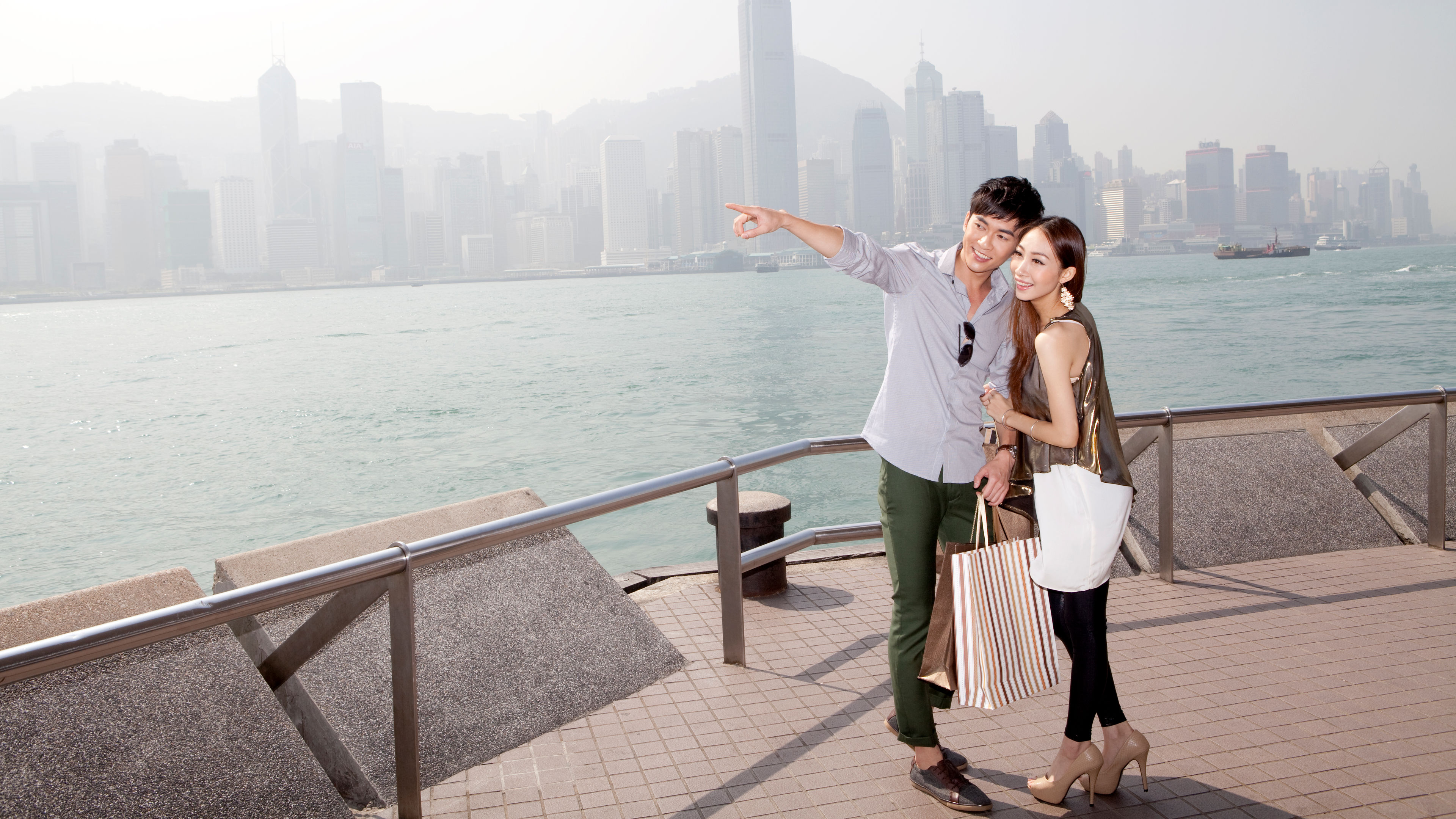 A happy young couple looking at a view near the sea 