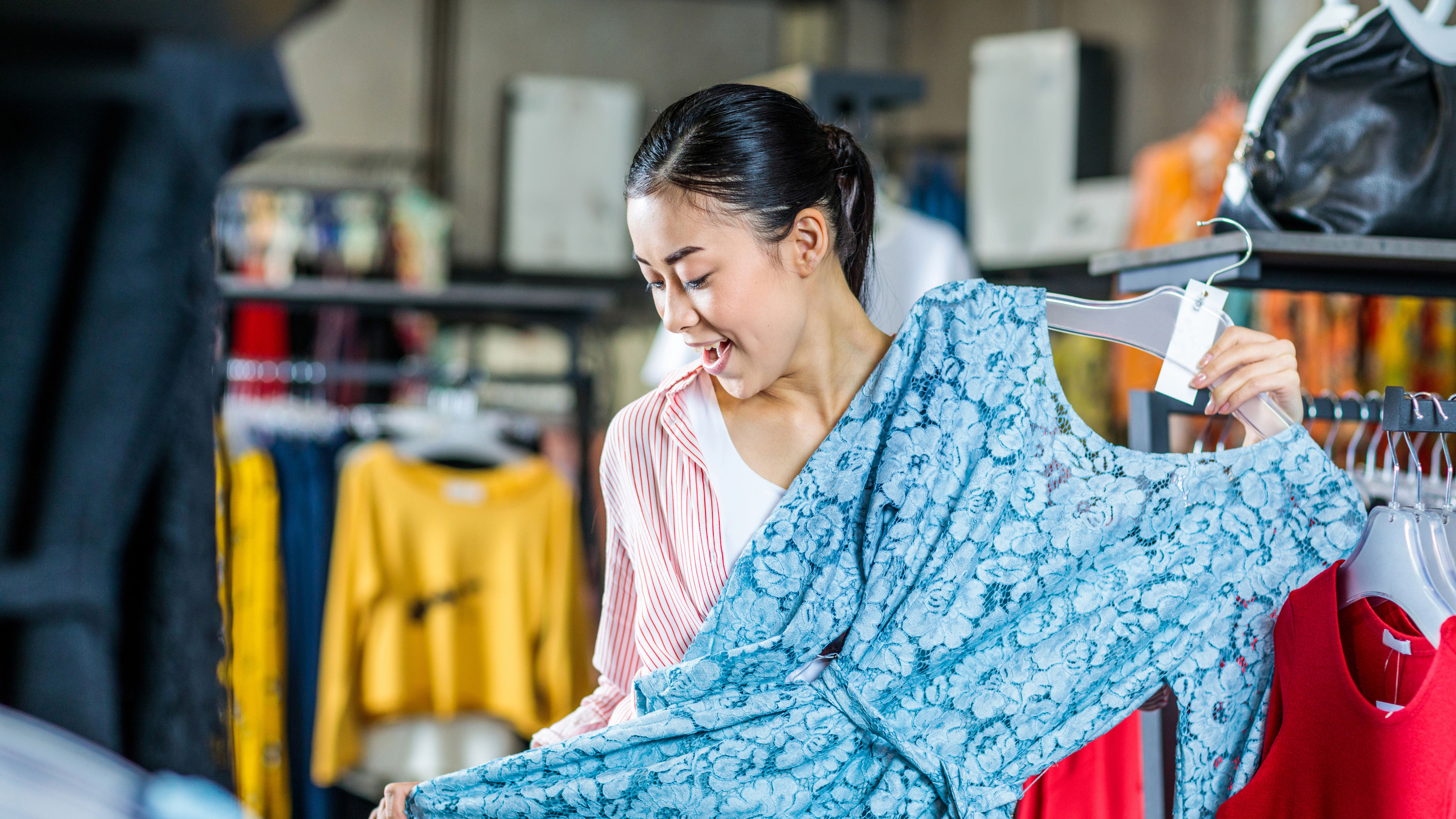 asian hipster girl choosing clothes in shopping mall