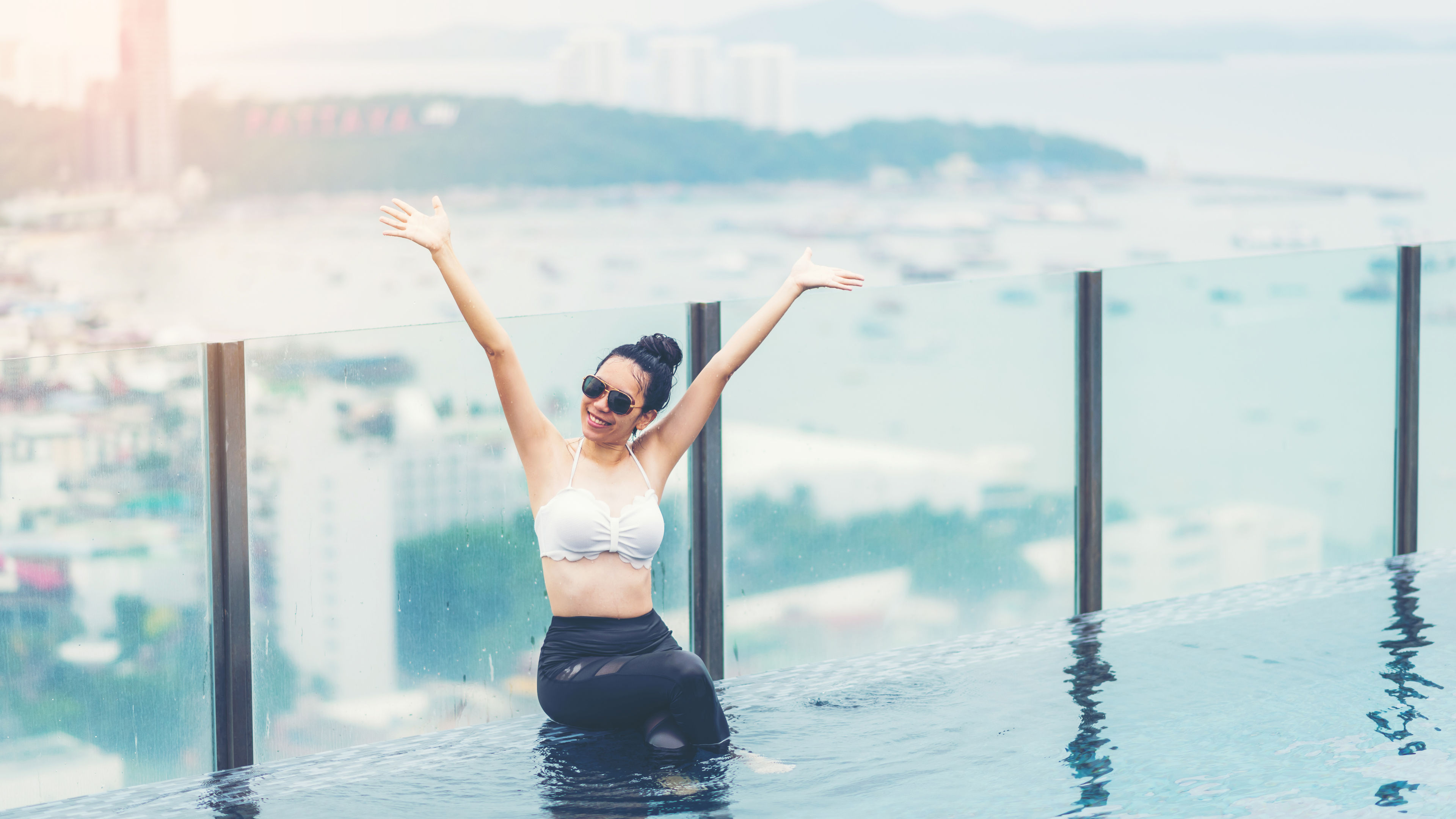 A smiling Asian woman enjoying the pool in a hotel 