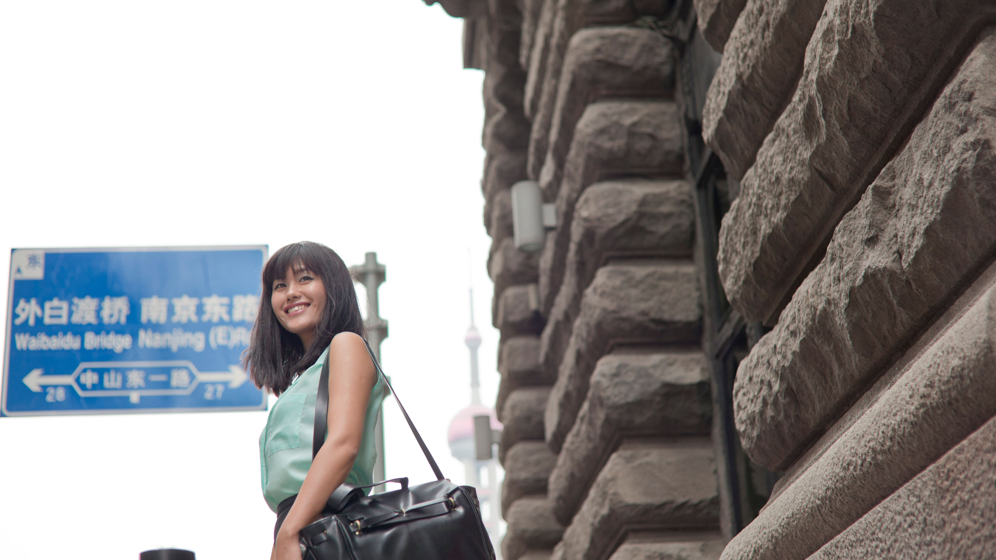 A young businesswoman smiling confidently outdoors, showcasing her professional and stylish demeanour 