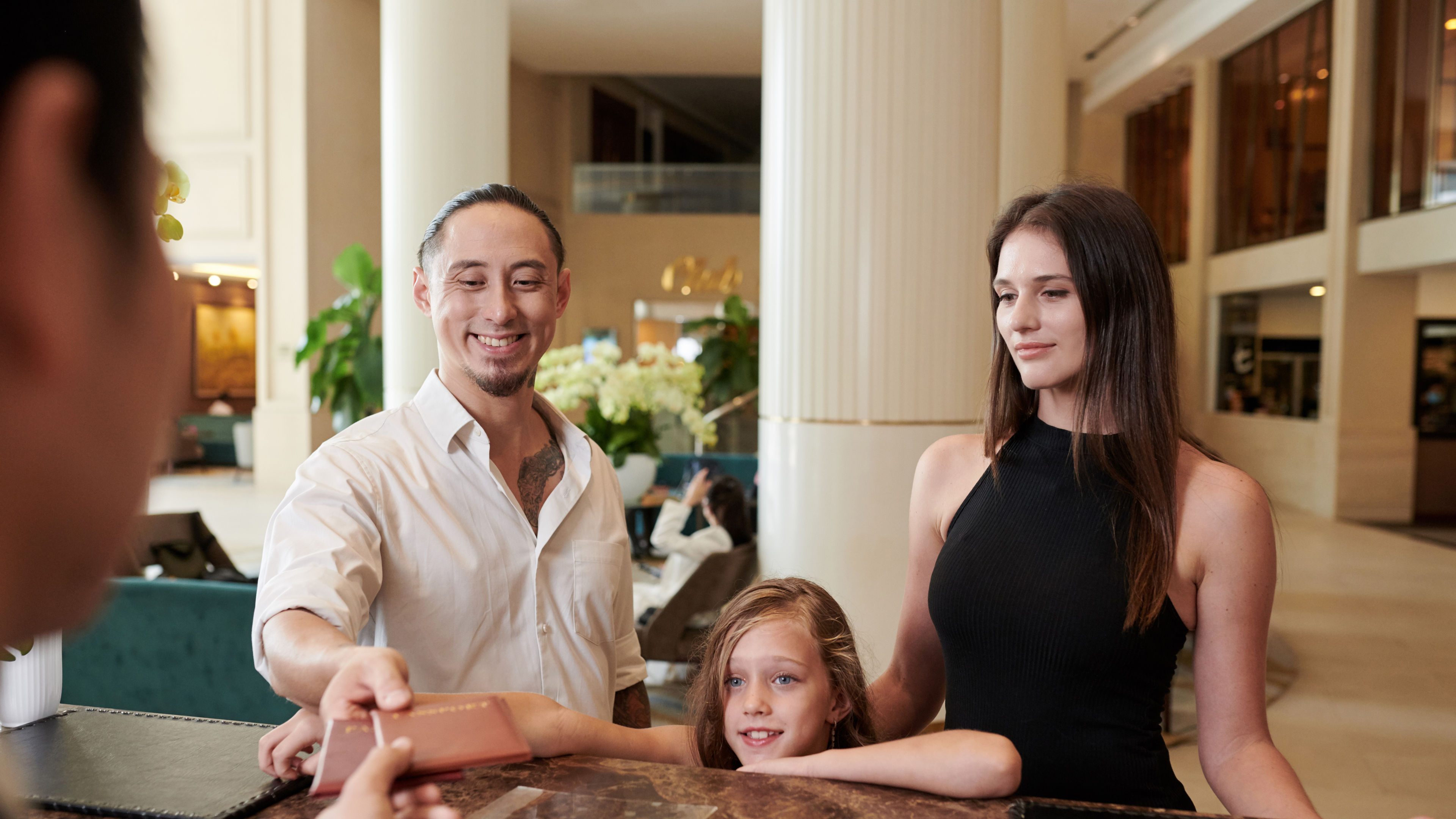 Family checking in at a hotel reception, ready for a comfortable stay. 