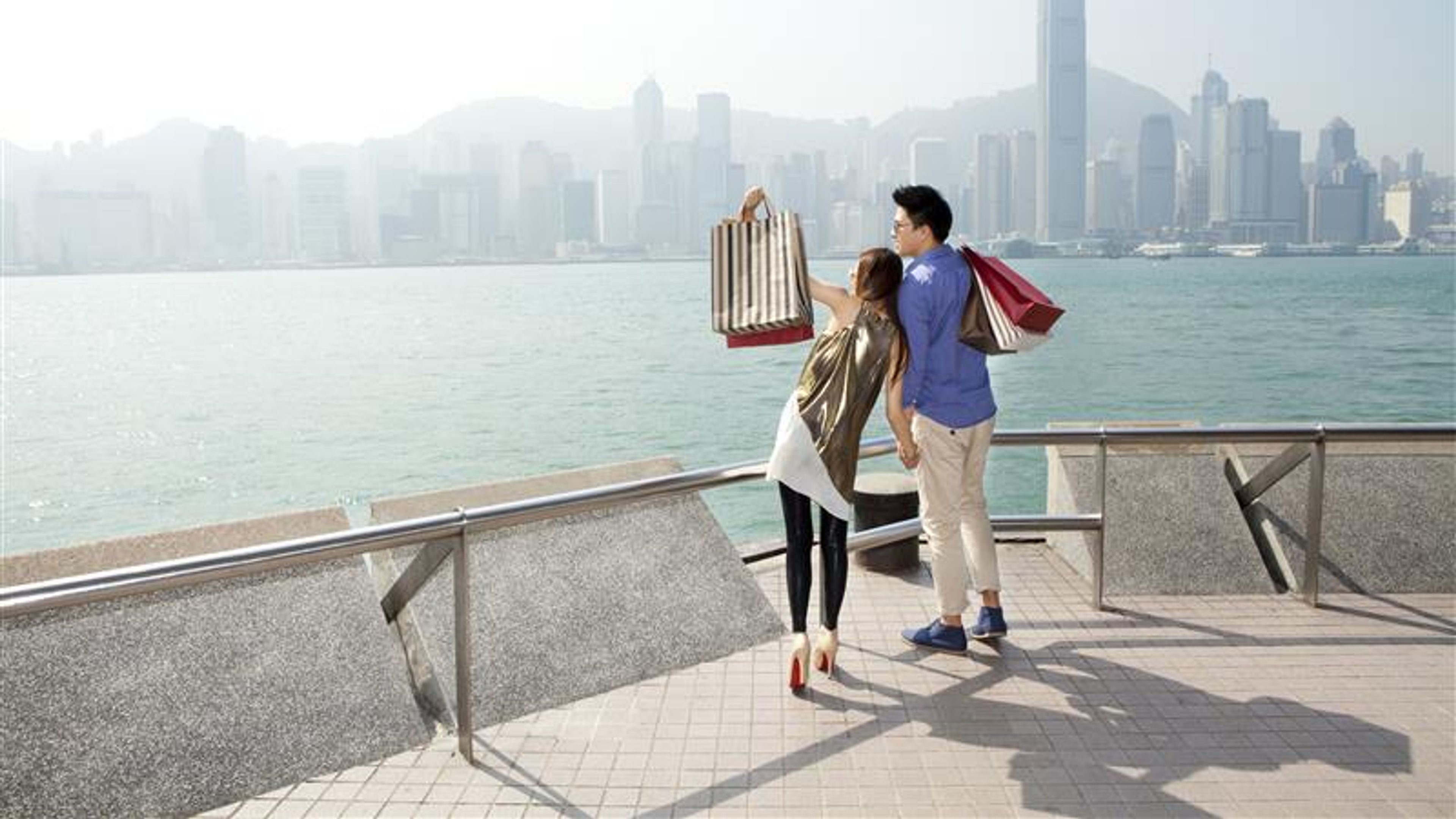 Fashionable young couple with shopping bags enjoying the victoria harbor, Hong Kong