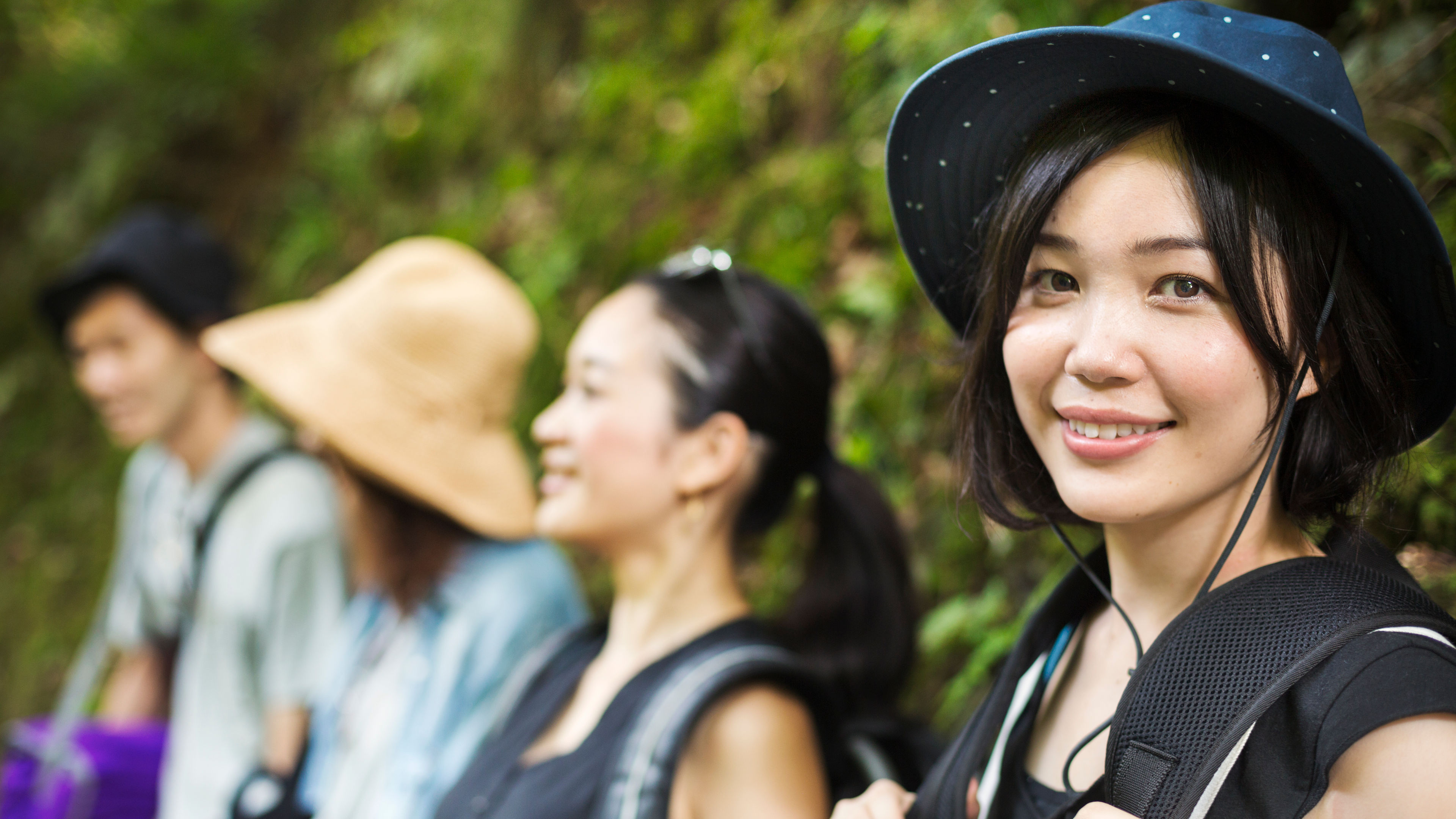 A vibrant portrait of three stylish young women and a confident man, showcasing wide looks and personalities against a dynamic background. 