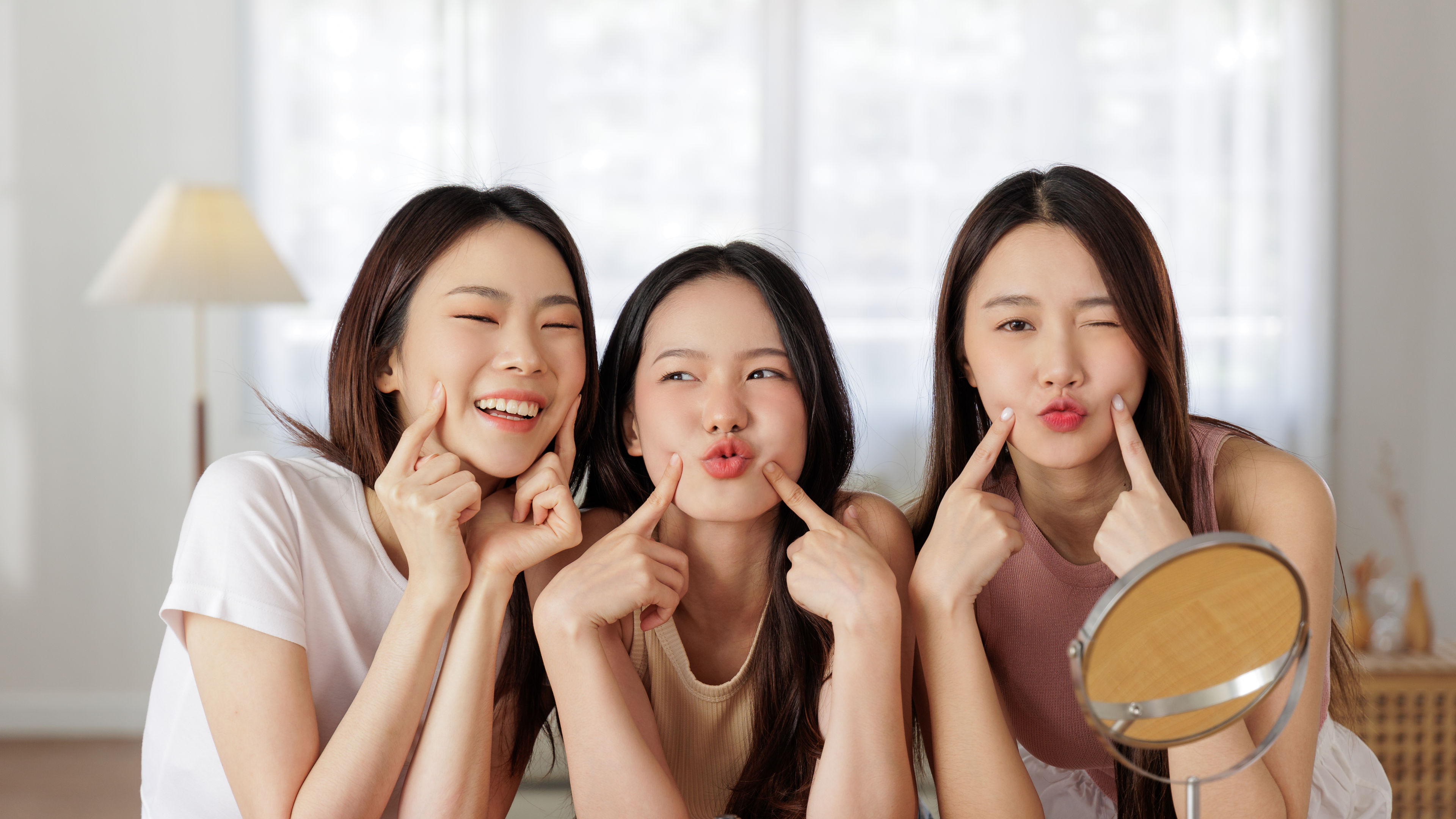 Three girls having fun with their make up products 