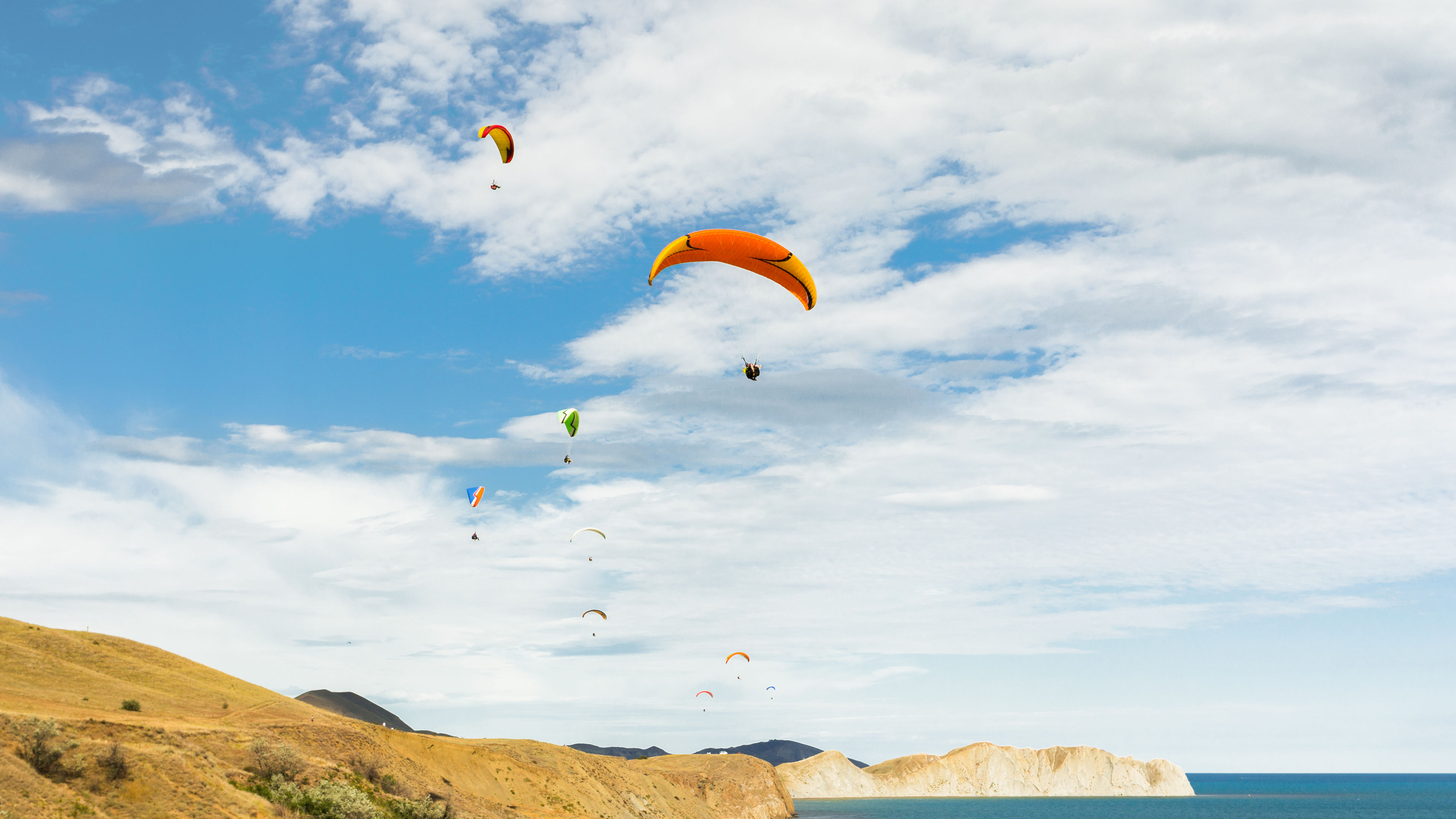 Image of paragliders soaring through the sky 