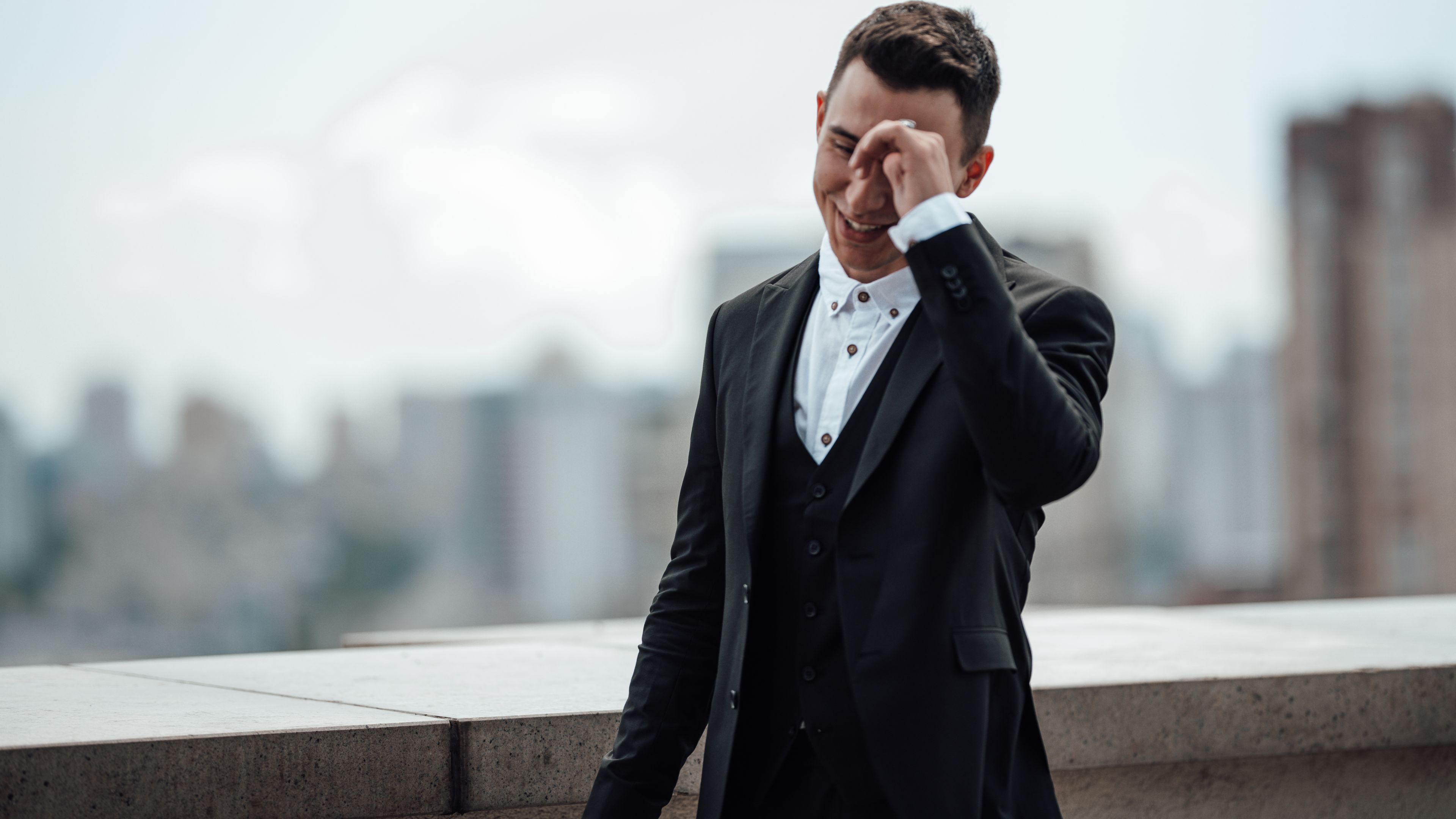 Stylish lovely fiance in formal evening wear is going to wedding ceremony outdoor wearing black suit