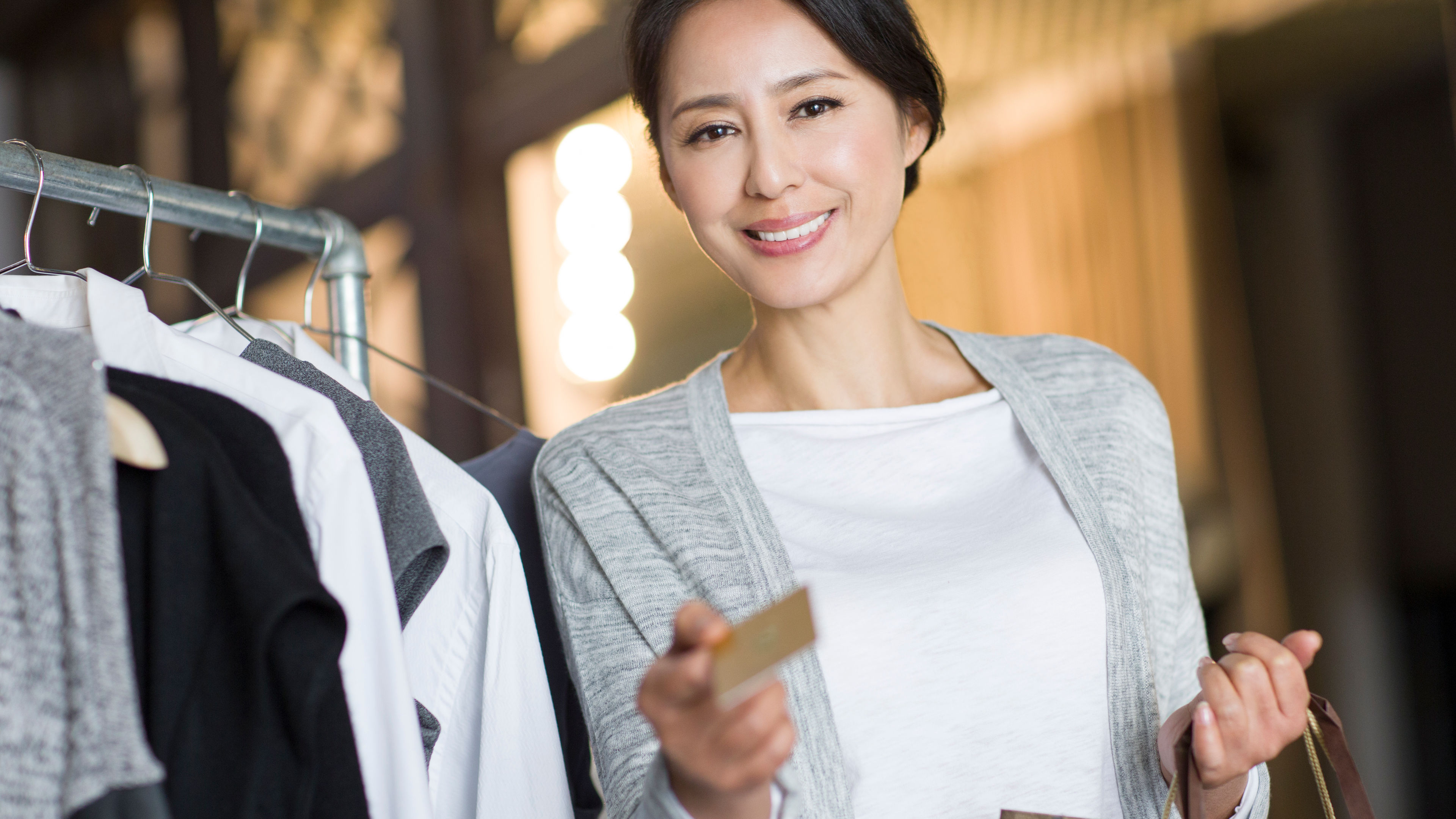 Picture of a woman with credit card near clothes 