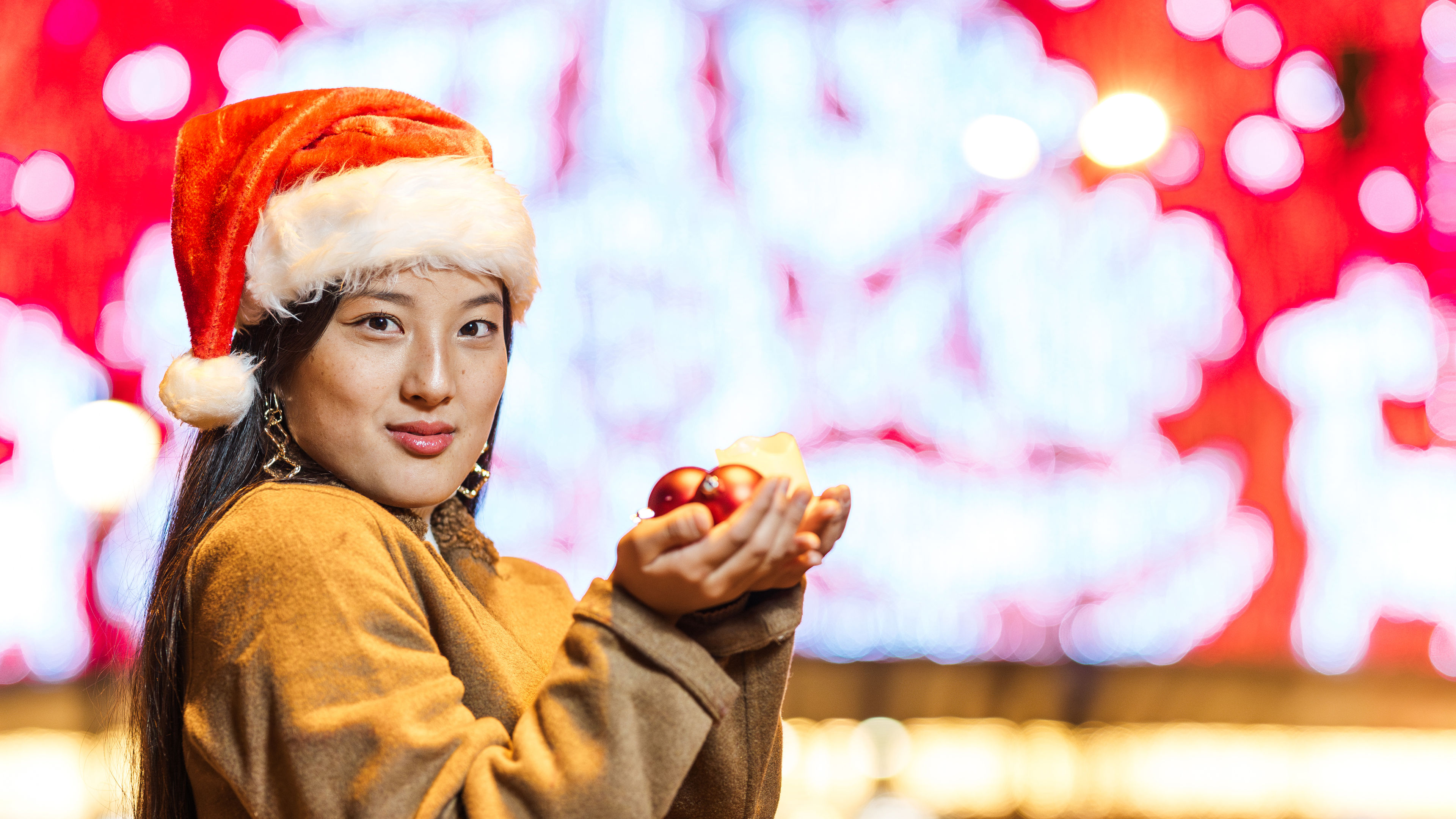 Image of Young woman wearing santa hat 